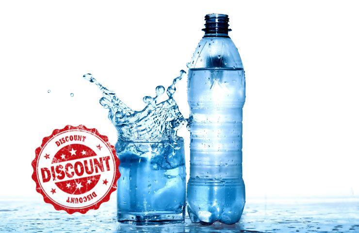 la scritta discount e un bicchiere con la bottiglia dell'acqua