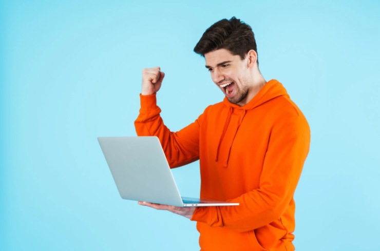 uomo che esulta con il computer in mano