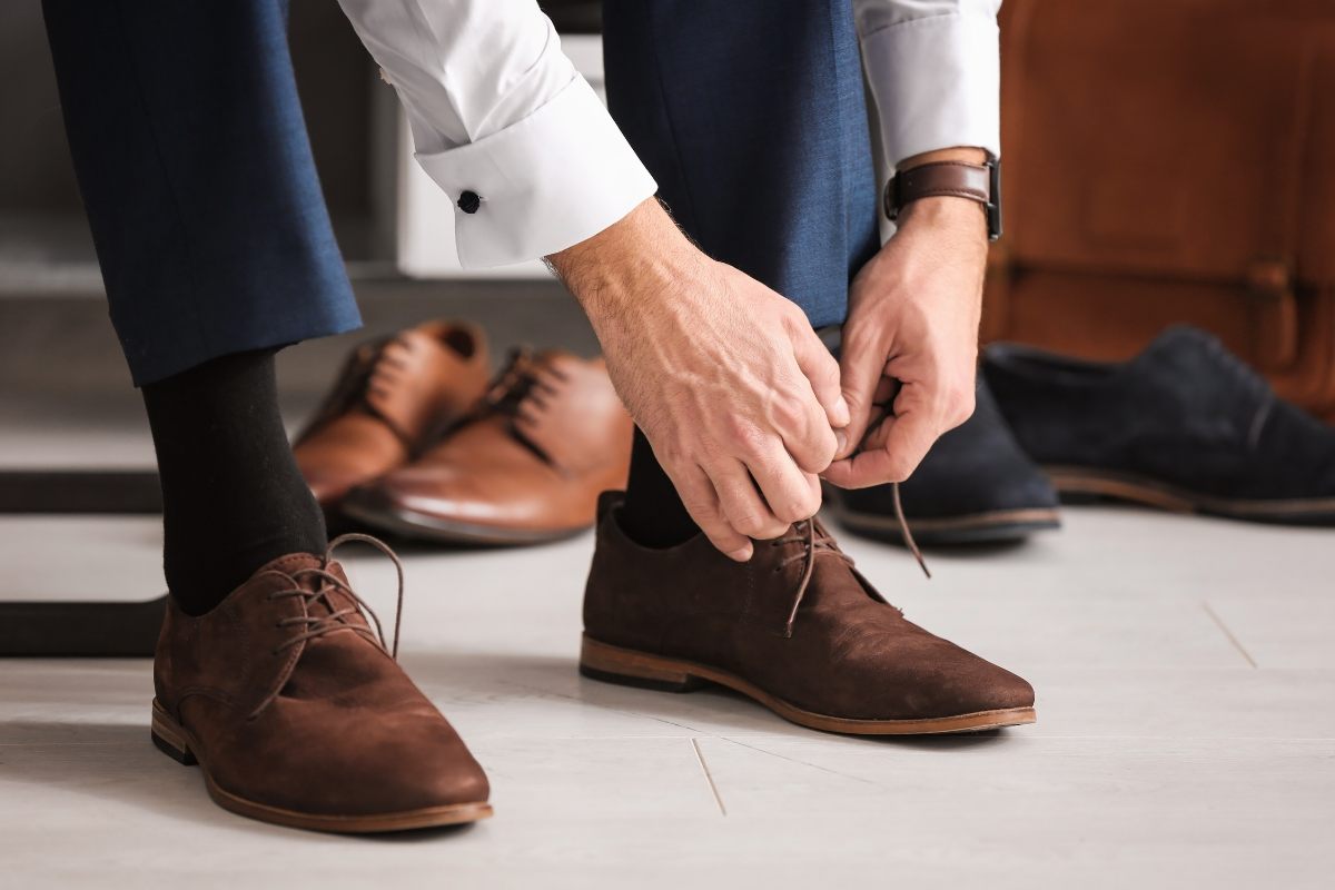persona che si sta sistemando i lacci delle scarpe